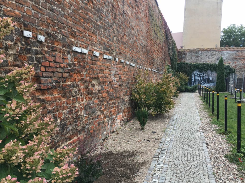 The wall outside the Post Office with fingerprint 
plaques showing where the captured postal workers were forced to stand with their hands against the wall
