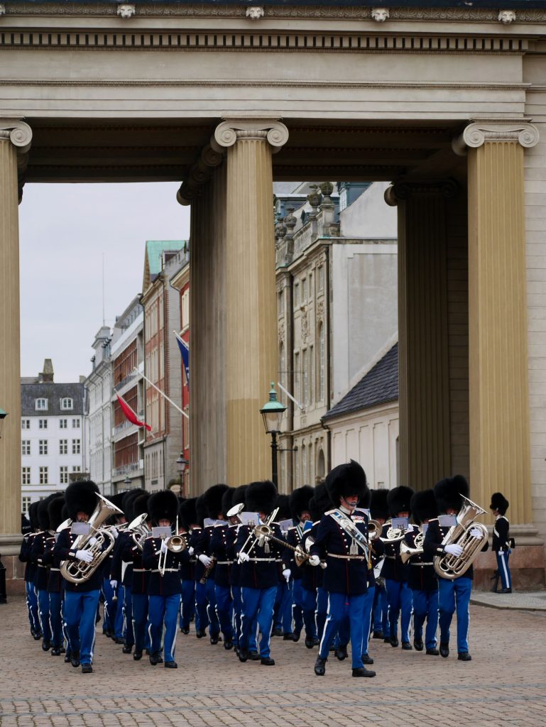 The Changing of the Guards at the Amalienborg Palace, Copenhagen.  shows the guards marching and the band playing.