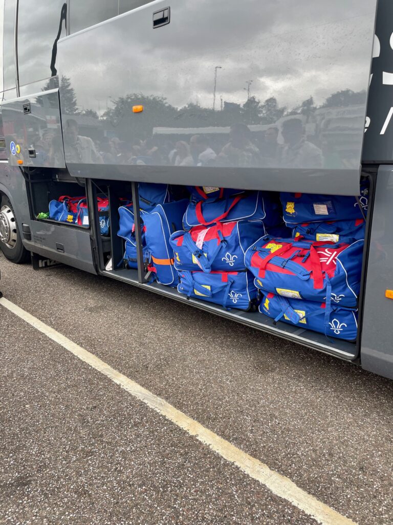 Lots of UK Scout holdalls packed in the luggage compartment of the coach.