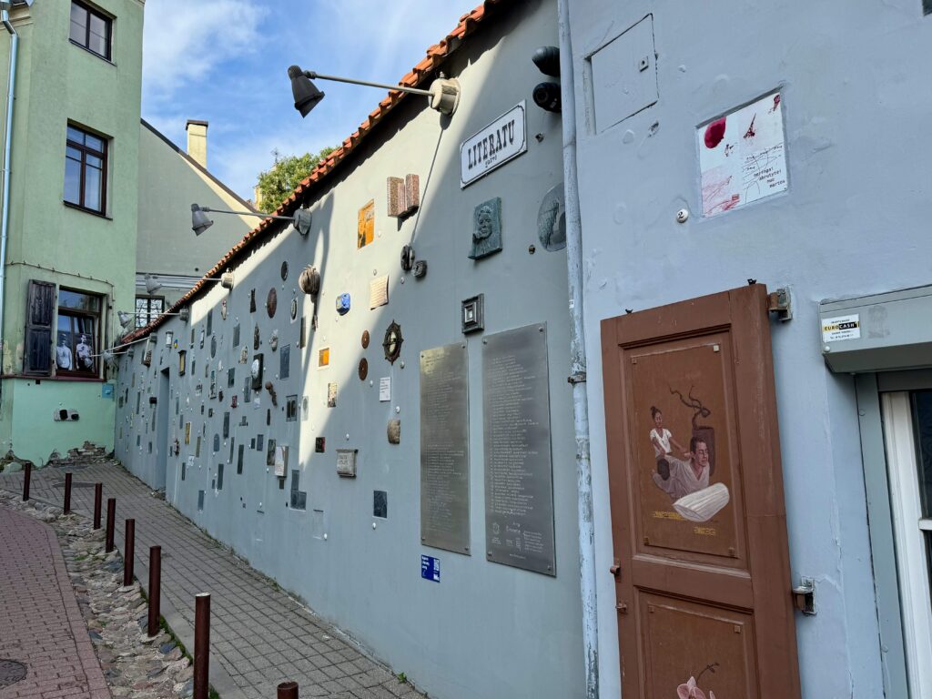 A blue wall is adorned with many plaques and pictures.