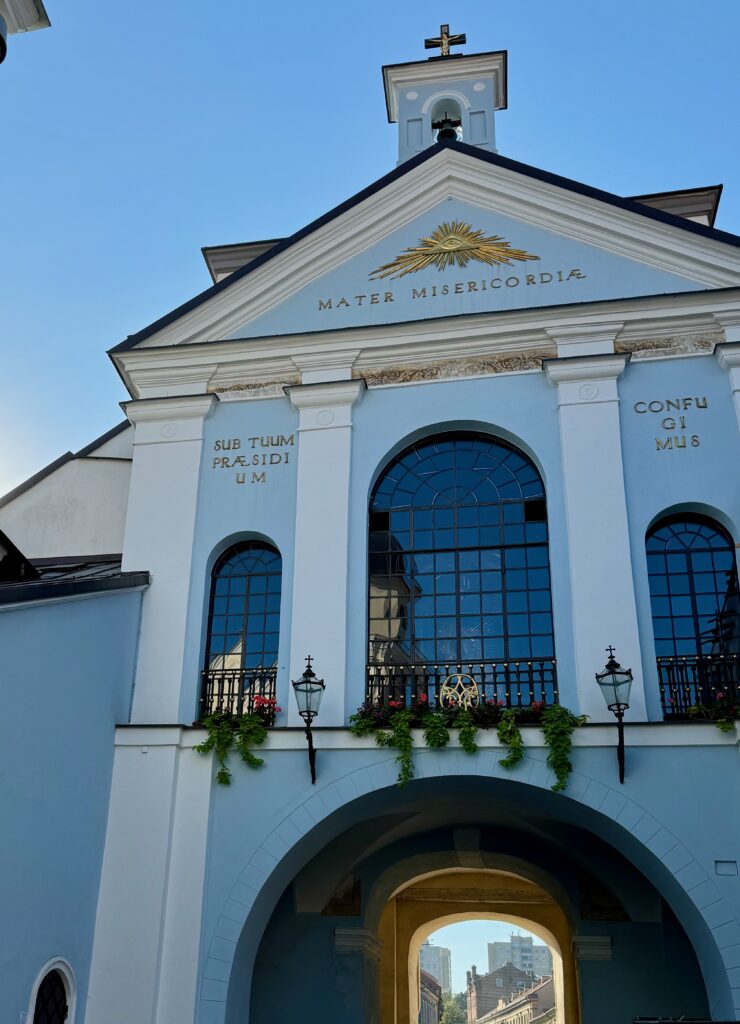 A blue chapel with a large window over the Gate of Dawn, the entry into Vilnius Old Town.