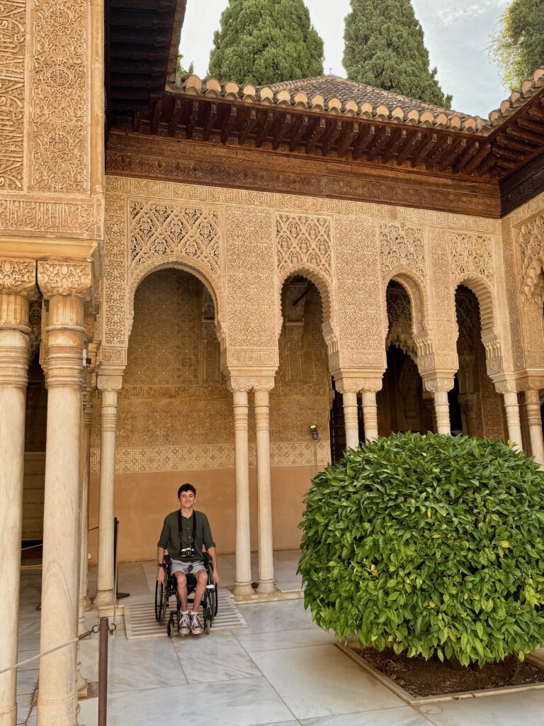 The image shows a wheelchair user going down a ramp to access the courtyard.